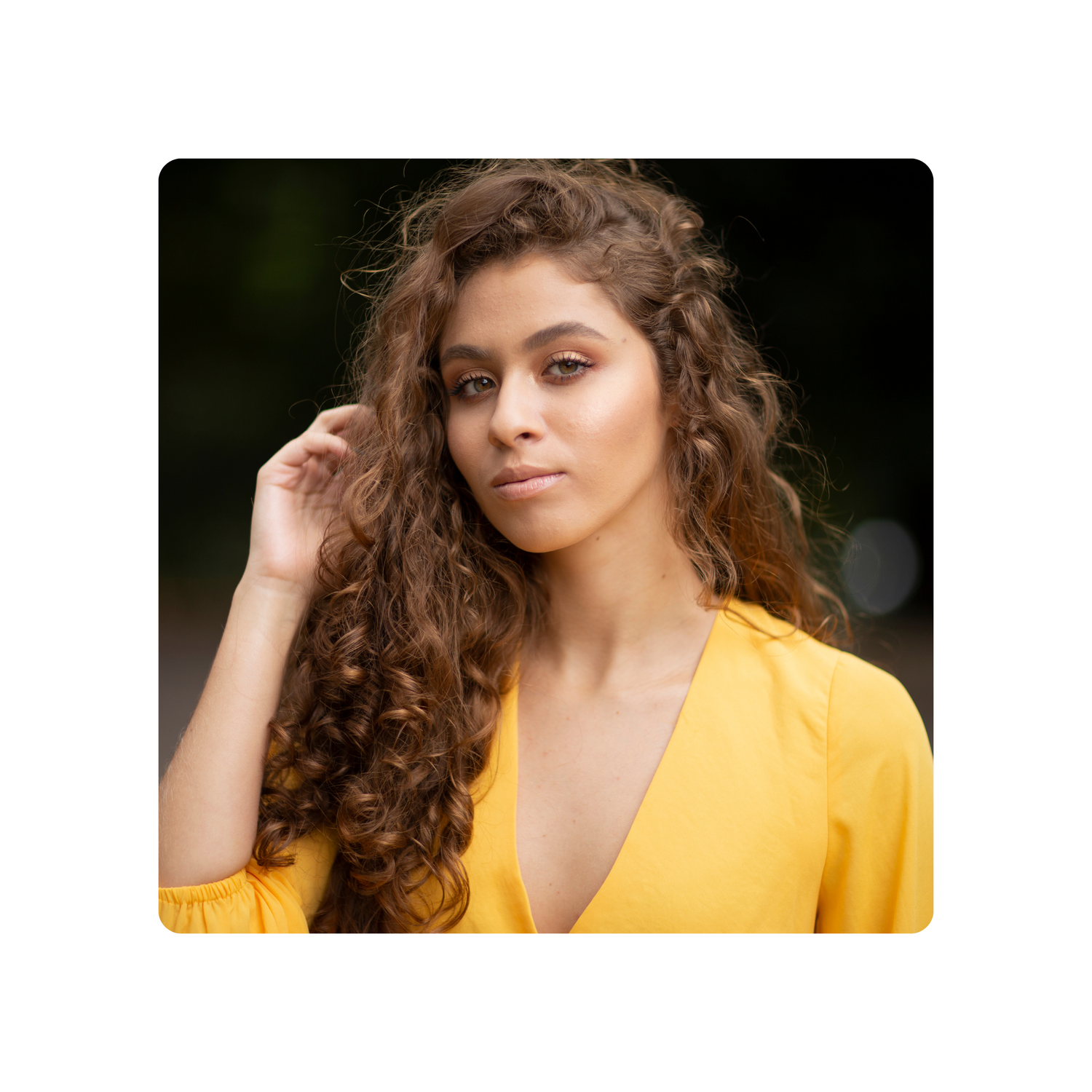 A confident woman in a vibrant yellow shirt, standing gracefully with a warm smile, embodying elegance and positivity great skin and face.